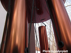 Close-up of bronze metal windchimes with a copper color and black strings, copper wind chimes, beautiful wind chimes.