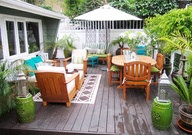 Outdoor deck/patio furniture sets, wooden outdoor furniture with patio umbrella on patio deck deck with blue cushions.