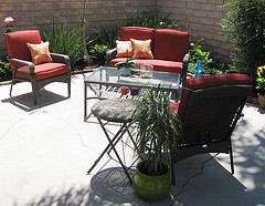  Discount Outdoor Furniture, Wicker loveseat with two chairs in red with coffee table and plant on top.