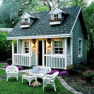 Outdoor garden furniture, outdoor white wicker furniture in front of small house.