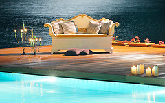Outdoor Furniture Pillows, glamorous outdoor deck loveseat with straight pillows and candles in front of pool.