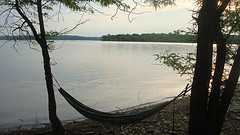 camping hammocks,backpacking hammock,Hammock hanging in trees by lake.