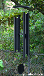 Black powder coated long tube windchimes with resin striker and black string hung on a tree, large windchimes, deep tone windchimes.