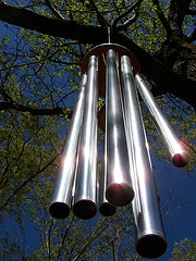 Long stainless steel tube garden wind chimes with sun shining on them.Musical wind chimes, tuned wind chimes.
