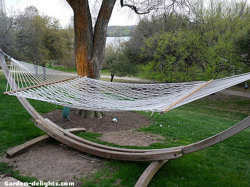  White hand woven cotton hammock mounted on wooden hammocks stand in relaxing backyard garden. Relaxing hammocks, hammocks summer, backyard hammocks, comfortable hammock, hammock bed.
