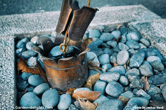  Tulip style rain cup on the end of the rain chain sitting in a rock bed pot with water in it, pure copper tulip rain chain, green pantina rain chain, polished copper rain cups,dirty gardening, downspout catch, rain downspout.