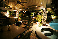 outdoor patio furniture sets, two patio sets by hot tub with bar and ceiling fans in outdoor patio living area.