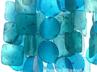 Aqua blue capiz wind chimes in bright sunlight showing vibrant translucent colors,capiz shells wind chimes,wind chime chandeliers,seashell windchimes,color windchimes.