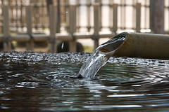 Bamboo reed pouring water into cleansing pool basin, outdoor water fountains, bamboo garden fountains.