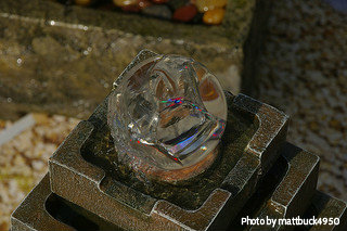 Crystal sphere with splashes of color (red, purple, green, black shades) on top of multitier square ceramic fountain, tabletop ceramic fountains, custom crafted fountains.