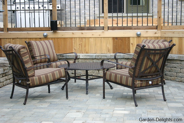 Five piece Brown wrought iron patio set on paving stones in front of Cedar deck and barbecue, Wrought Iron Patio Furniture, low maintenance patio furniture, patio decor themes.
