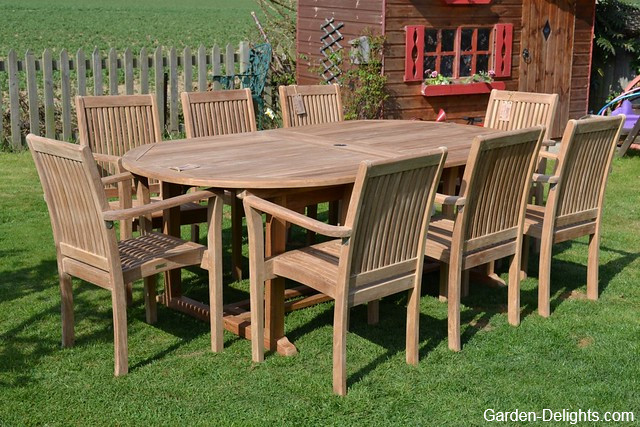 Large wooden patio dinette set with a chairs and table set up on the lawn with children's Playhouse in the background, aluminum patio furniture, wood patio furniture, wrought iron patio furniture.